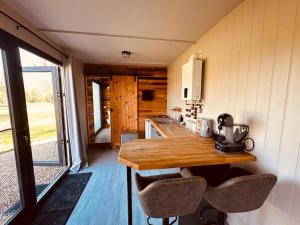 a kitchen with a wooden table in a tiny house at Casterton stays in Tickencote