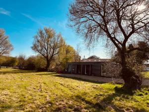a house in a field next to a tree at Casterton stays in Tickencote +10 photos