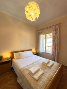 a bedroom with a bed with two towels on it at Dina Apartment in Ágios Rókkos