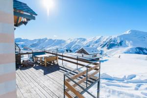 une terrasse en bois avec un banc au sommet d'une montagne dans l'établissement Gudauri Private Cottage 2, à Goudaouri