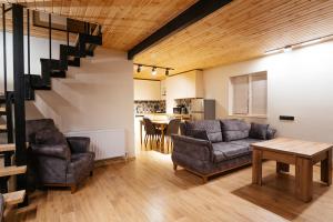 un salon avec un canapé, des chaises et une table dans l'établissement Gudauri Private Cottage 2, à Goudaouri