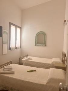a hospital room with two beds and a mirror at Ichnos experience room in Villasimius