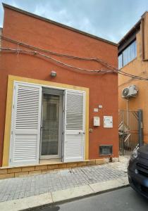 a building with a shutter on the side of it at Casa Letizia a 2 passi dal centro in Marsala