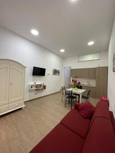 a living room with a red couch and a table at Casa Letizia a 2 passi dal centro in Marsala