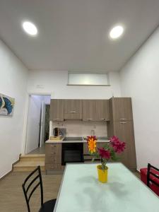 a kitchen with a table with a vase of flowers on it at Casa Letizia a 2 passi dal centro in Marsala