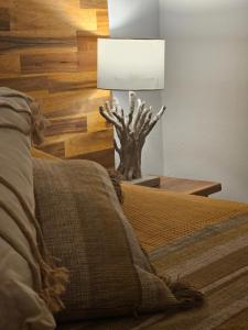 a bedroom with a bed and a lamp on a table at Vue mer exceptionnelle, Calme & tout confort, plage à pied in Le Gosier +21 photos