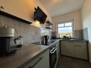 a kitchen with a sink and a stove at Ferienwohnung Naturkraft mit Tiefgaragenstellplatz und Balkon in Oberhof