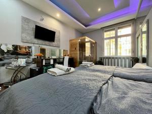 a large bedroom with a large bed with purple lighting at JohnGold Wellness Room in Debrecen