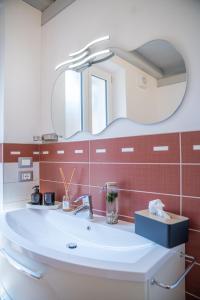 een badkamer met een wastafel en een spiegel bij ES Apartments in Nago-Torbole