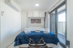 1 Schlafzimmer mit einem blauen Bett und 2 Stühlen in der Unterkunft "1103 - Studio Moderno e Completo no Campo Belo!" in São Paulo + 38 Fotos