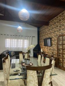 a dining room with a glass table and chairs at Chácara aconchegante, próximo Águas de Santa Bárbara in Santa Bárbara do Rio Pardo +18 photos