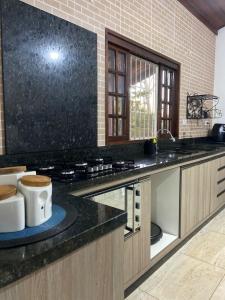 a kitchen with a stove and a counter top at Chácara aconchegante, próximo Águas de Santa Bárbara in Santa Bárbara do Rio Pardo