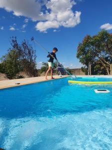 a person standing on a rope in a swimming pool at Chácara aconchegante, próximo Águas de Santa Bárbara in Santa Bárbara do Rio Pardo