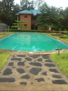 a swimming pool in front of a house at Fanaka Safaris Campsite & Lodges in Mto wa Mbu