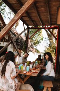 MiramarCoco Bamboo Beach Camp的一群人坐在桌旁吃饭