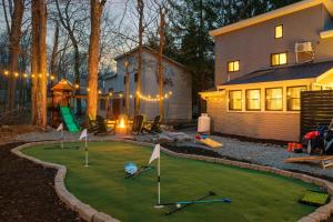 ein Hinterhof mit einem Putting Green mit Golfschlägern in der Unterkunft Sleeps 15 Sauna Hot Tub Fire Pit & Putt Putt in Tobyhanna