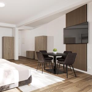 a living room with a table and chairs and a tv at WzW Apartments - Wohnraum zum Wohlfühlen in Neubrandenburg