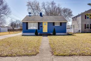 a blue house with a yellow door in a yard at Rockne's Rally - Updated 3BR 2BA Home 1 Mile from ND in South Bend