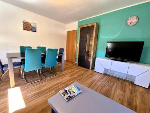 a living room with a table and a flat screen tv at Sonnenschein1L mit Terrasse und Garten in Friedrichshafen