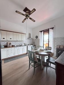 a kitchen with a table and a ceiling fan at Biancal'aura in Borghesiana  +16 photos