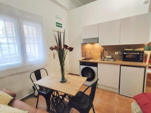a kitchen with a table with a vase of flowers on it at Estudio El Santo 1 in Salamanca +1 photo