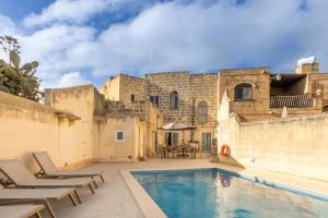 a villa with a swimming pool and patio furniture at Surwig Gozitan Villa & Pool - Happy Rentals in Kerċem