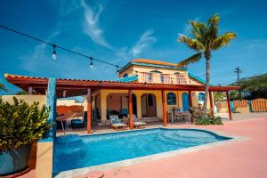 a house with a swimming pool in front of it at Villa Encantada Aruba in Noord