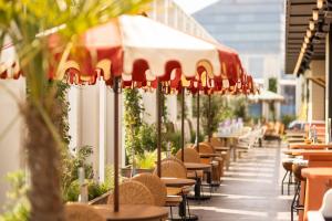 a row of tables and chairs with umbrellas on a building at The Hoxton, Brussels in Brussels