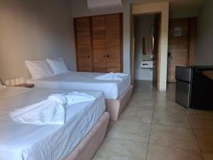a hotel room with two beds and a television at Hotel TORTUGA REAL in Santa Cruz Huatulco