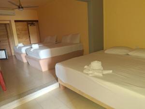 a hotel room with two beds with towels on them at Hotel TORTUGA REAL in Santa Cruz Huatulco