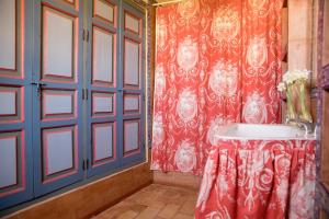 a bathroom with a sink and a red wall at Casa Palacio de los Palma in Écija +37 photos