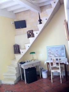 Cette chambre dispose d'un escalier avec une table et une chaise. dans l'établissement Hostellerie Provençale, à Uzès