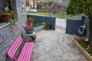 a pink bench sitting next to a wall with plants at Mona Lisa Guest House in Volos