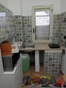 una cucina con scrivania, lavandino e finestra di B&B EmaNik a Gioia Tauro