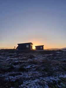 斯蒂克松鲁姆Bygghamar的地里的房子,背景是日落