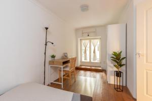 a bedroom with a bed and a desk and a window at Buda or Pest in Budapest
