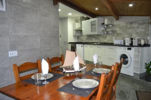 una sala da pranzo con un tavolo e una cucina di O Chalé Bela a Setúbal Altre 11 foto