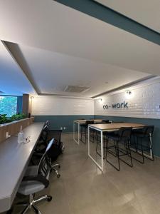 un bureau avec des tables et des chaises et un panneau sur le mur dans l'établissement Liberdade Loft & Comfort, à São Paulo
