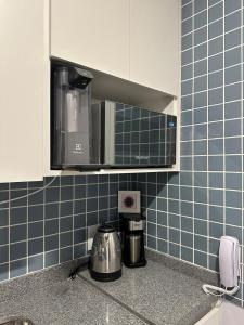 - une cuisine avec des murs carrelés bleus et un four micro-ondes dans l'établissement Liberdade Loft & Comfort, à São Paulo