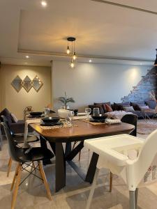 a dining room with a table and a couch at Boho 2BR Cozy App Jacuzzi & Pool in Rabat