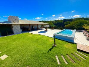 a house with a large yard with a swimming pool at Chalé Cantinho da Paz in Santa Teresa