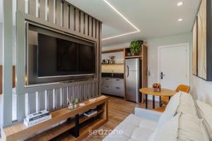 a living room with a large flat screen tv on a wall at Sua estadia perfeita em Urubici começa aqui! CZZ in Urubici