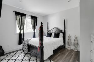 Un dormitorio con una cama con un edredón blanco y negro. en Shawnigan Lake Retreat with Theatre, en Shawnigan Lake