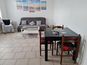 a living room with a table and a couch at Chez Anne in Verrières