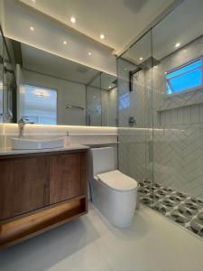 a bathroom with a toilet and a sink and a shower at Dolce Vita in Porto Belo