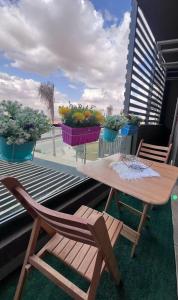 a table and chairs on a balcony with potted plants at Luxury Living - privado, Madinaty in Madinaty