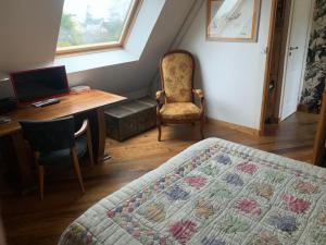 una camera da letto con un letto, una scrivania e una sedia di Chambres d'hôtes Villa Symphorien Surzur a Surzur