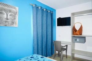 a blue room with a bed and a chair at HOTEL BELLAMAR in Cartagena de Indias