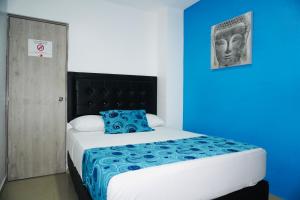 a bedroom with a large bed with a blue wall at HOTEL BELLAMAR in Cartagena de Indias