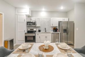 Una cocina con gabinetes blancos y una mesa con sillas. en Smart TV and Spacious Yard Peaceful Pope Retreat, en Pope